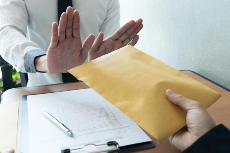 Persona rechazando un soborno en un entorno corporativo